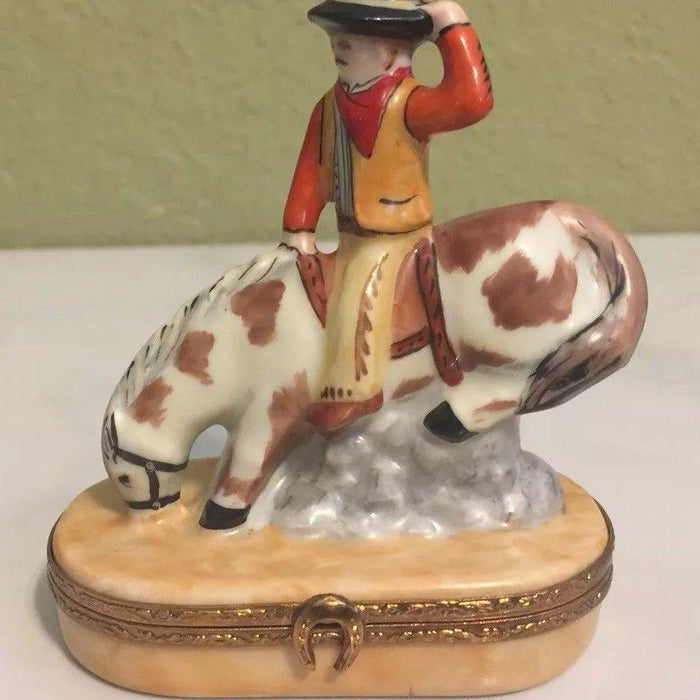 Decorative trinket box featuring a cowboy figurine riding a spotted horse on a beige base