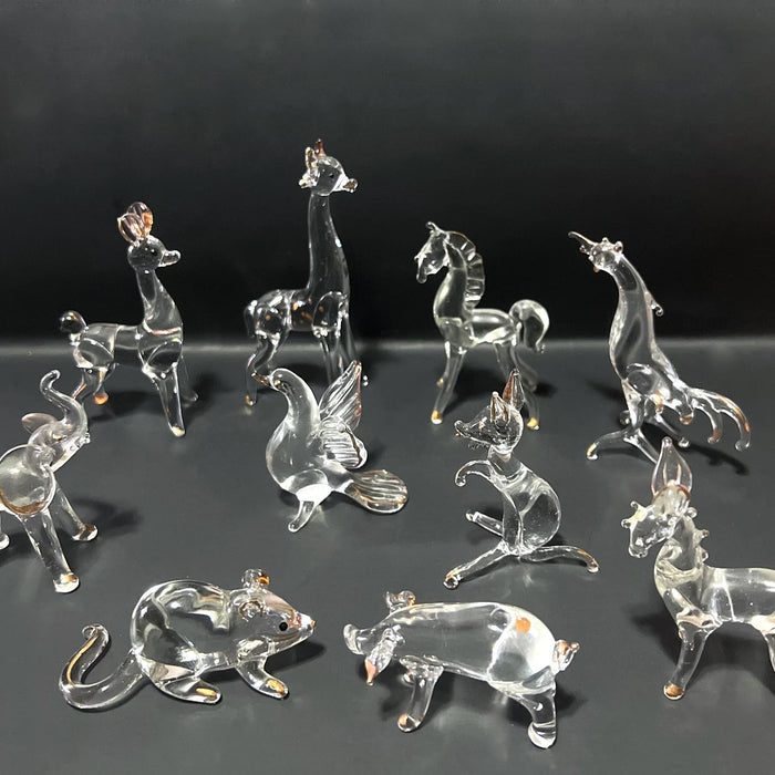 Collection of delicate crystal figurines for inside Limoges boxes showcasing various animal shapes on a black background