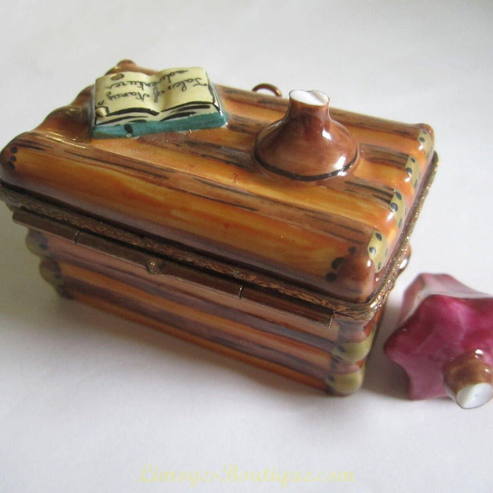 Ornate Limoges box shaped like a wooden desk with open book and inkwell demonstrating how to care for Limoges boxes