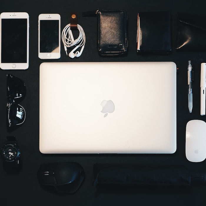 Flat lay of electronic devices and accessories arranged on a black surface resembling a luxury item France setup