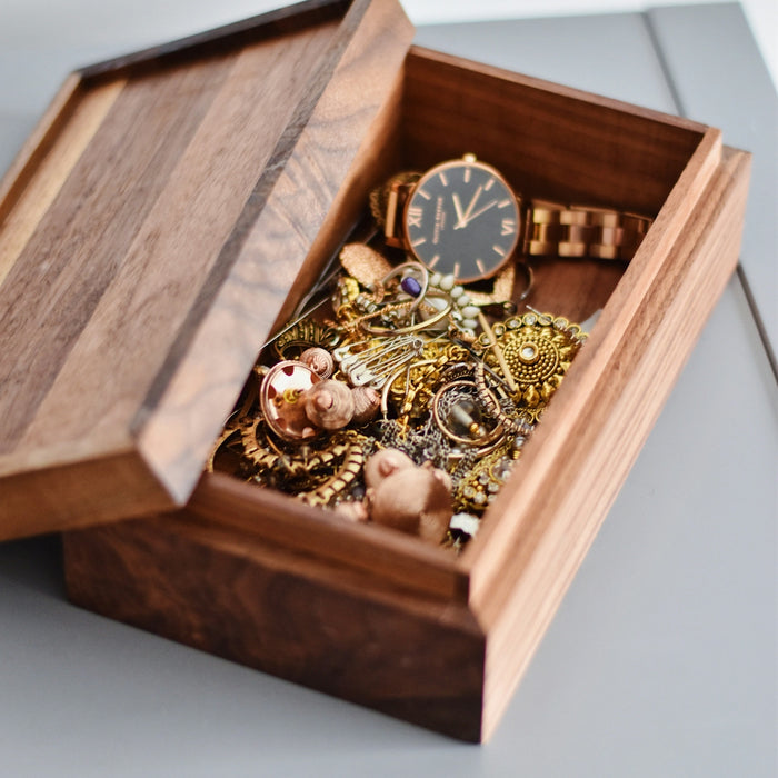 gold watch and pendant on brown wooden box