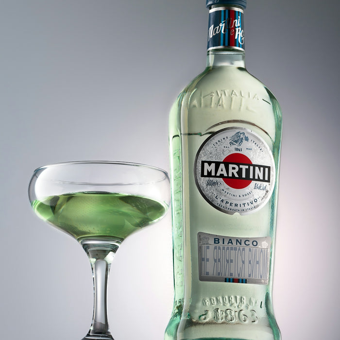 a bottle of alcohol next to a glass of green liquid