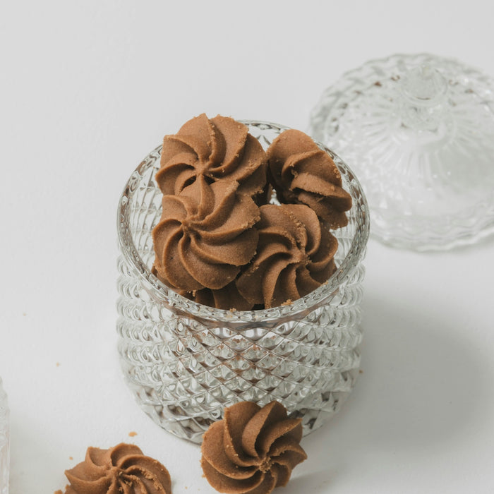 A small glass bowl filled with chocolate frosting