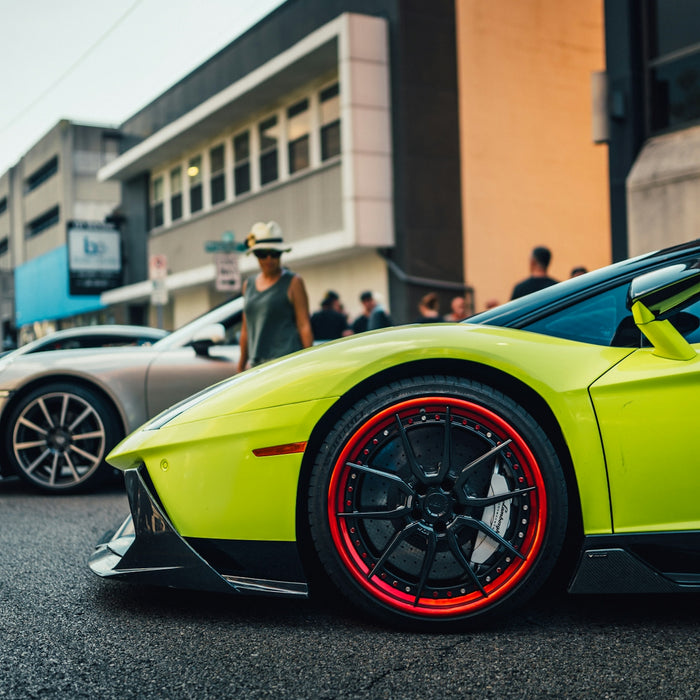 Lime green sports car with red rims on street