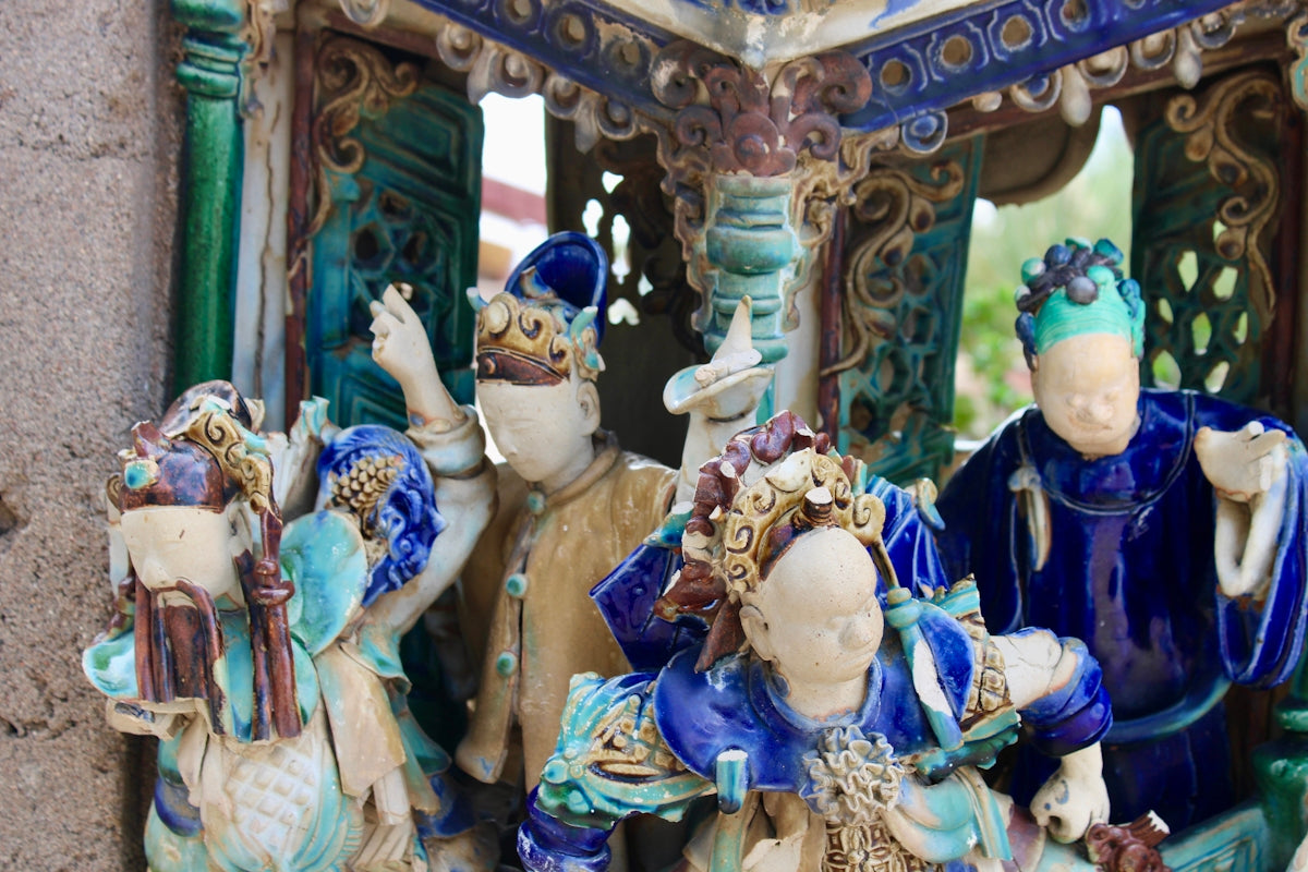 Ornate ceramic figurines of people in traditional attire