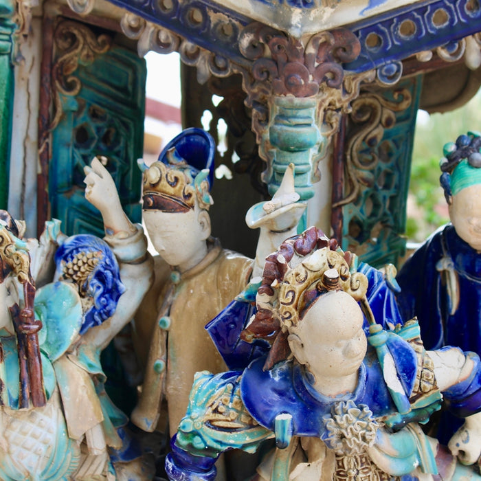 Ornate ceramic figurines of people in traditional attire