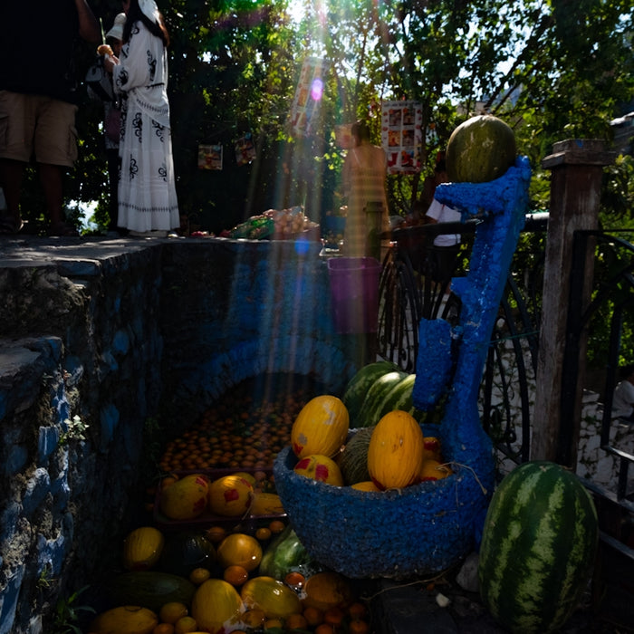 Various fruits displayed outdoors with sunlight shining.