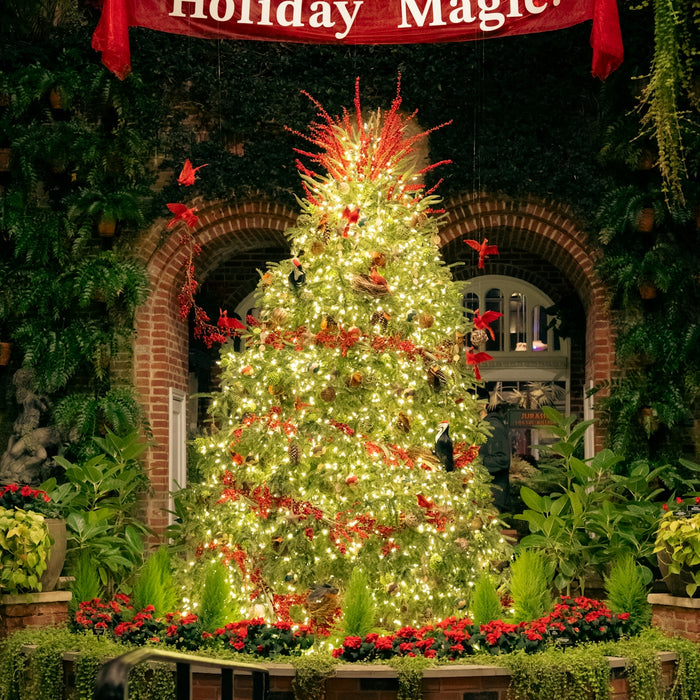 Decorated christmas tree with holiday magic banner.