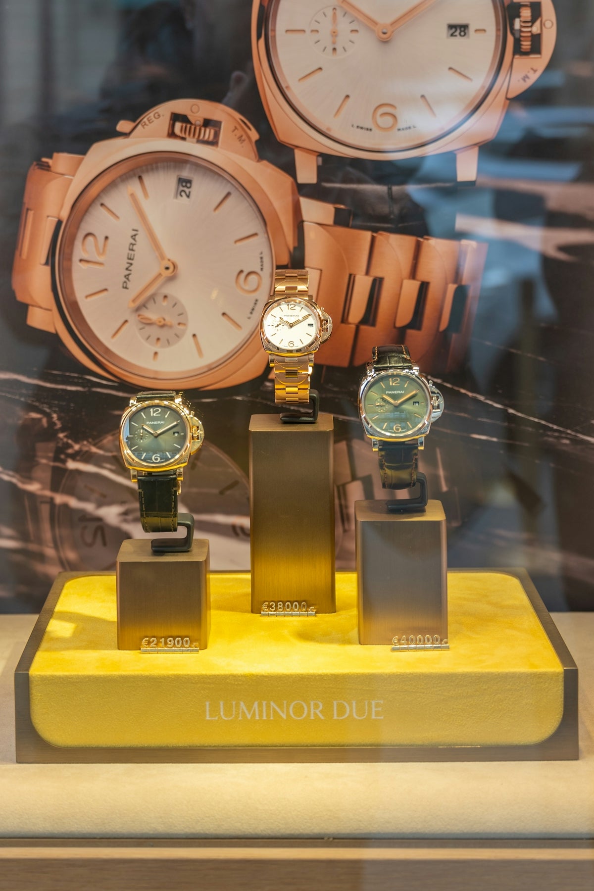 Three luxury watches displayed in a store window