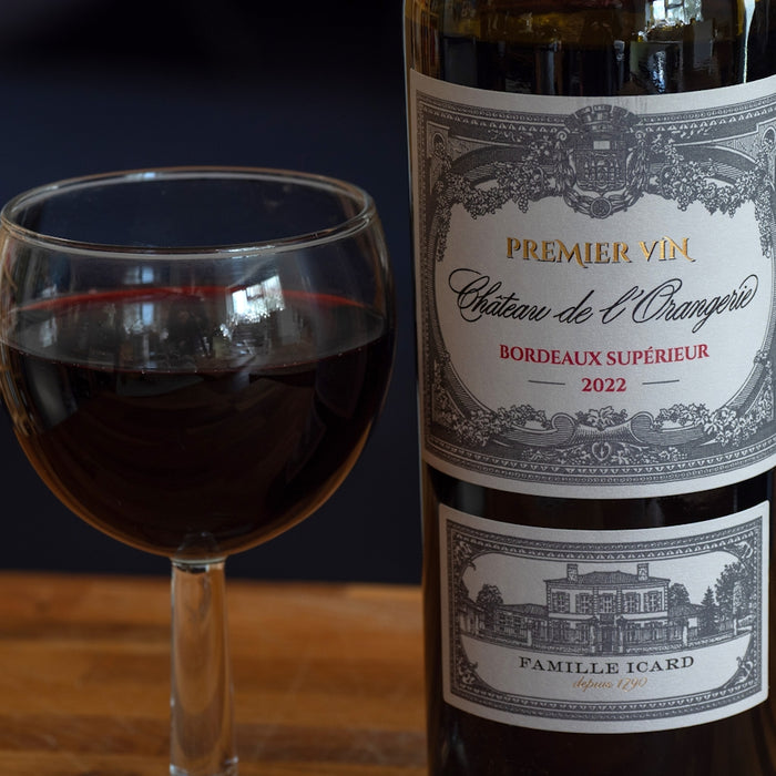 A glass of red wine next to a bottle