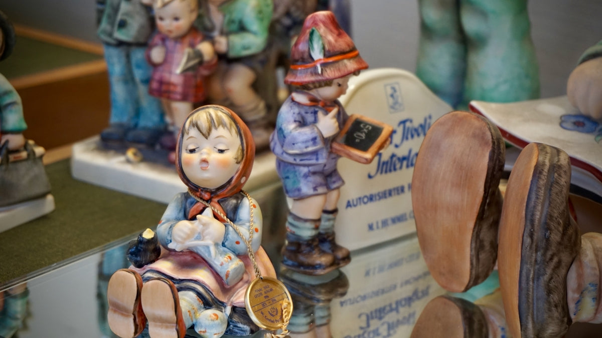 Figurines of children on a reflective surface.