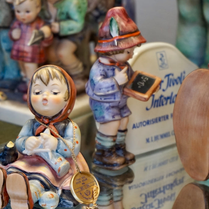 Figurines of children on a reflective surface.