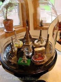 Miniature Eiffel Tower and other Paris landmarks displayed under glass illustrating history of Limoges boxes