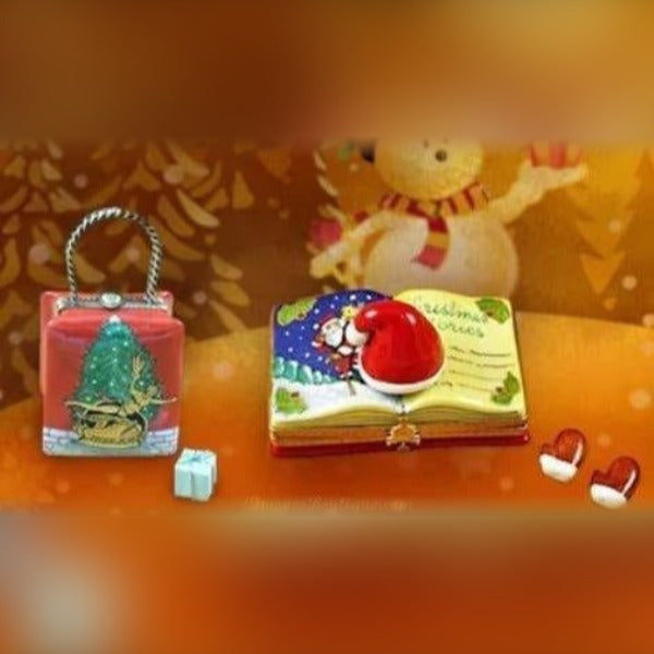 Christmas Themed Limoges boxes featuring a decorated Christmas tree and Santa hat on an open book figurine