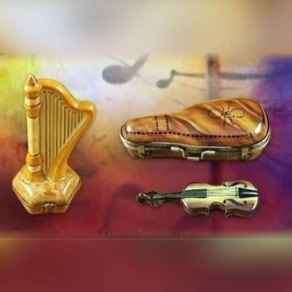 Hand-painted Limoges music box figurines shaped like a harp, violin, and case with fine porcelain details