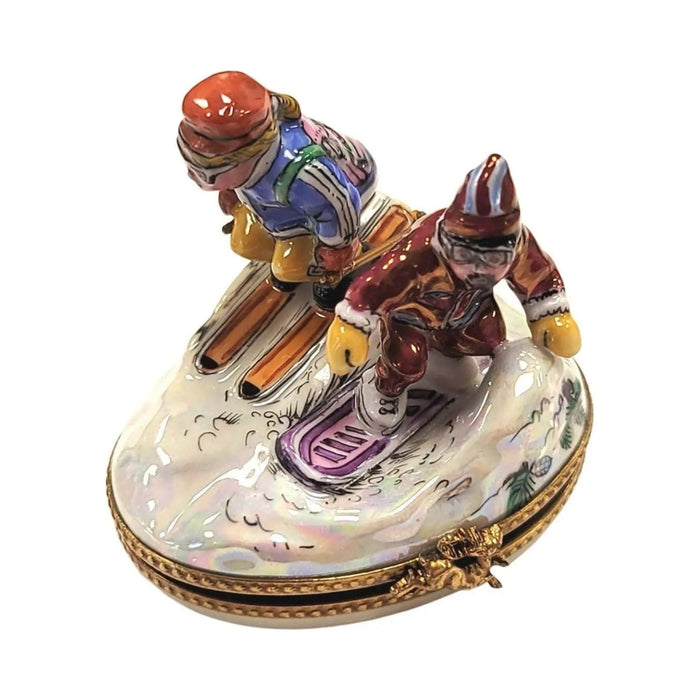 Two skiers carving down a pearly snow mound, three-quarter view of the Limoges box