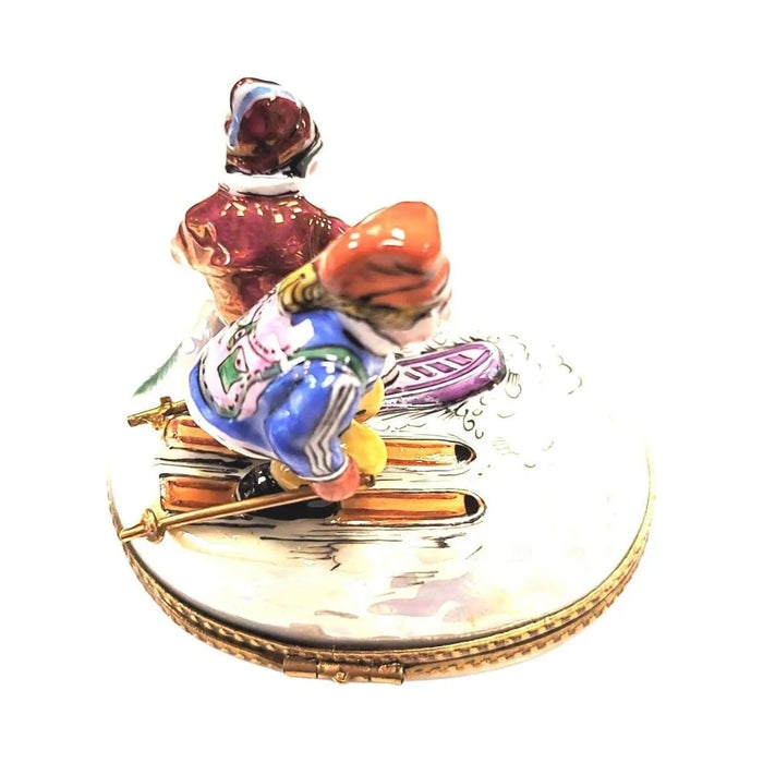 Skis and poles crossing from above on the skiers Limoges box, purple and orange details