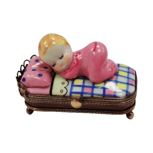 Limoges Boutique presents the Baby in Pink Bed Sleeping Newborn, a genuine Limoges box painted by hand in France