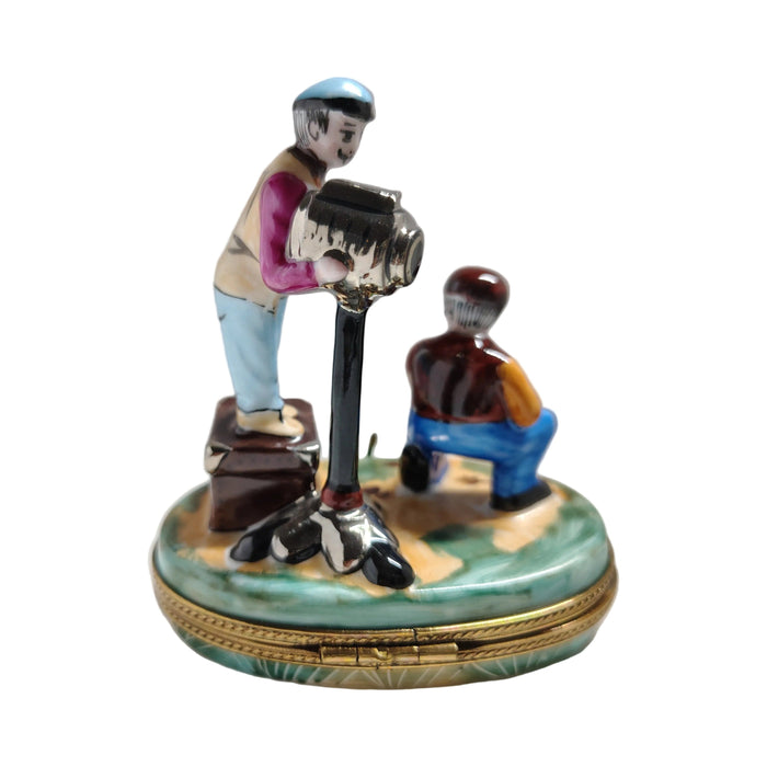 Cameraman behind the lens and assistant kneeling at the film crate, French artisan Limoges porcelain