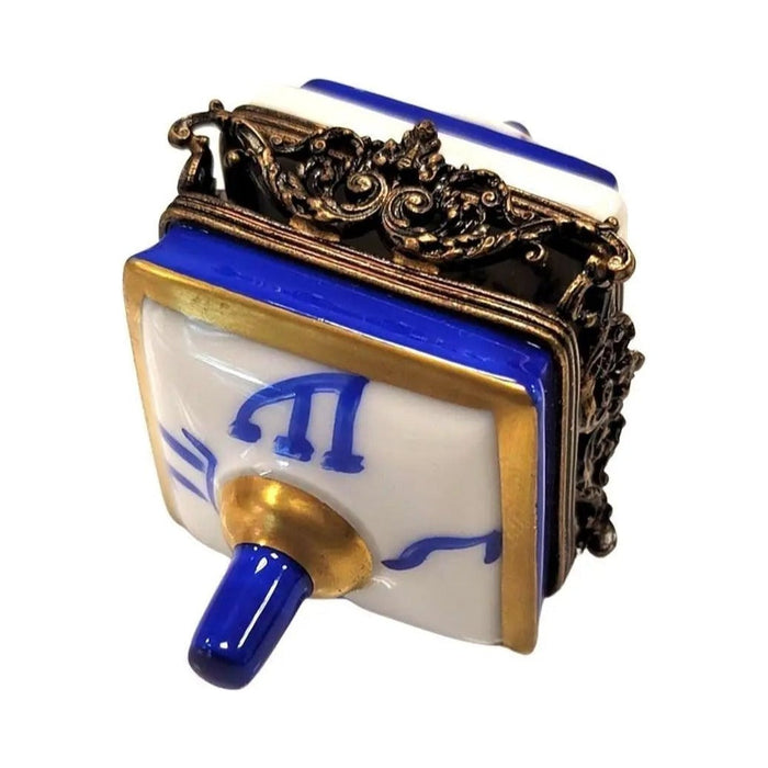 Every brushstroke by hand on the Brass White Dreidel Limoges box from France